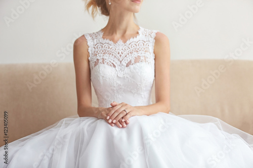Billede på lærred Bride in beautiful wedding gown sitting on sofa