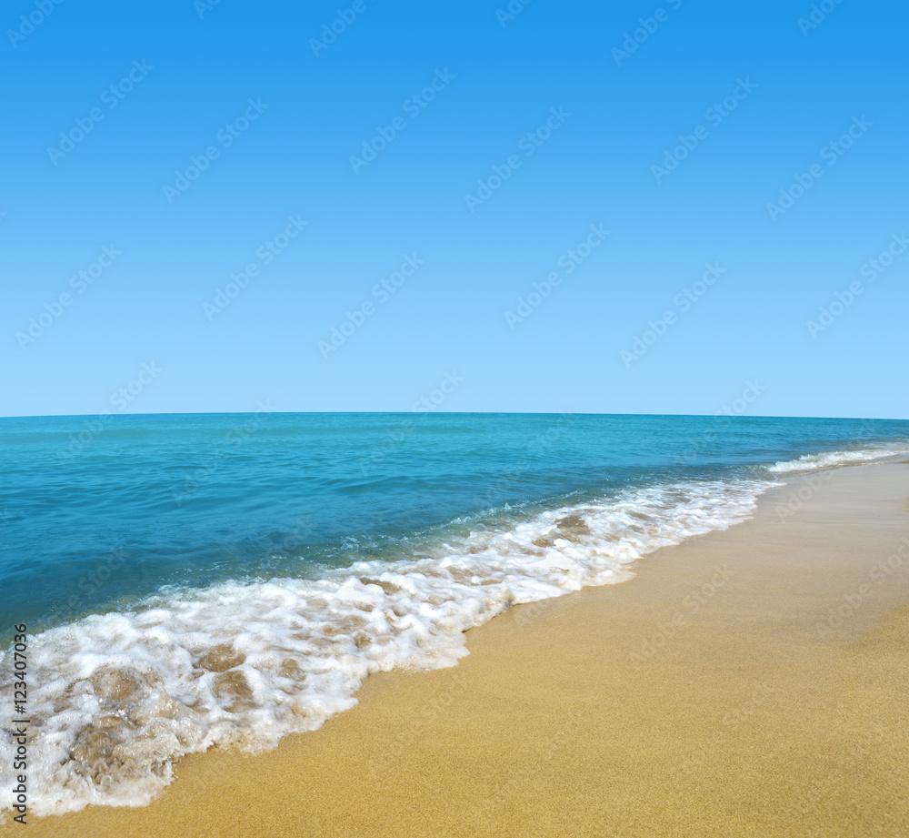 Blue sea and sky with sandy beach.