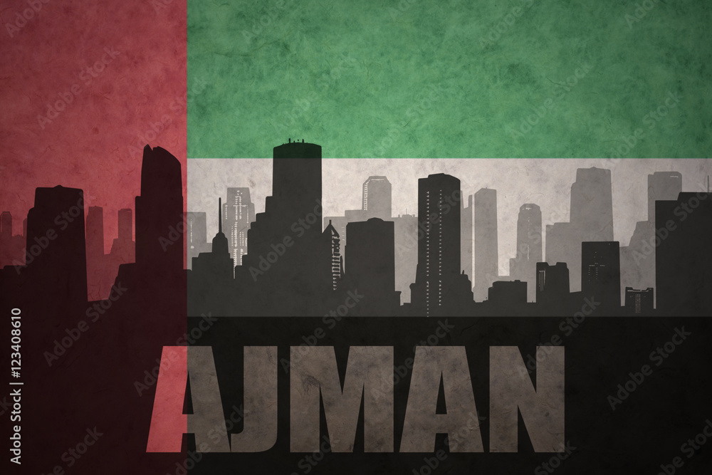 abstract silhouette of the city with text Ajman at the vintage united arab emirates flag background
