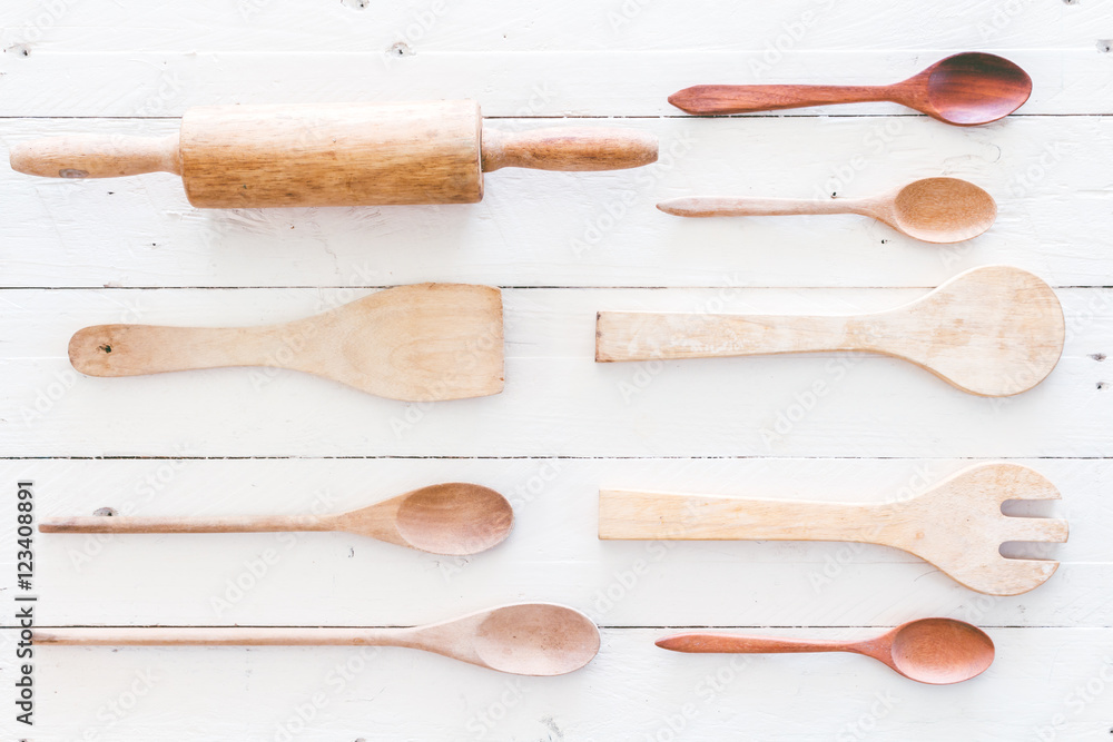 Wooden kitchen utensils on white wooden background Wooden kitchen utensils on white wooden background