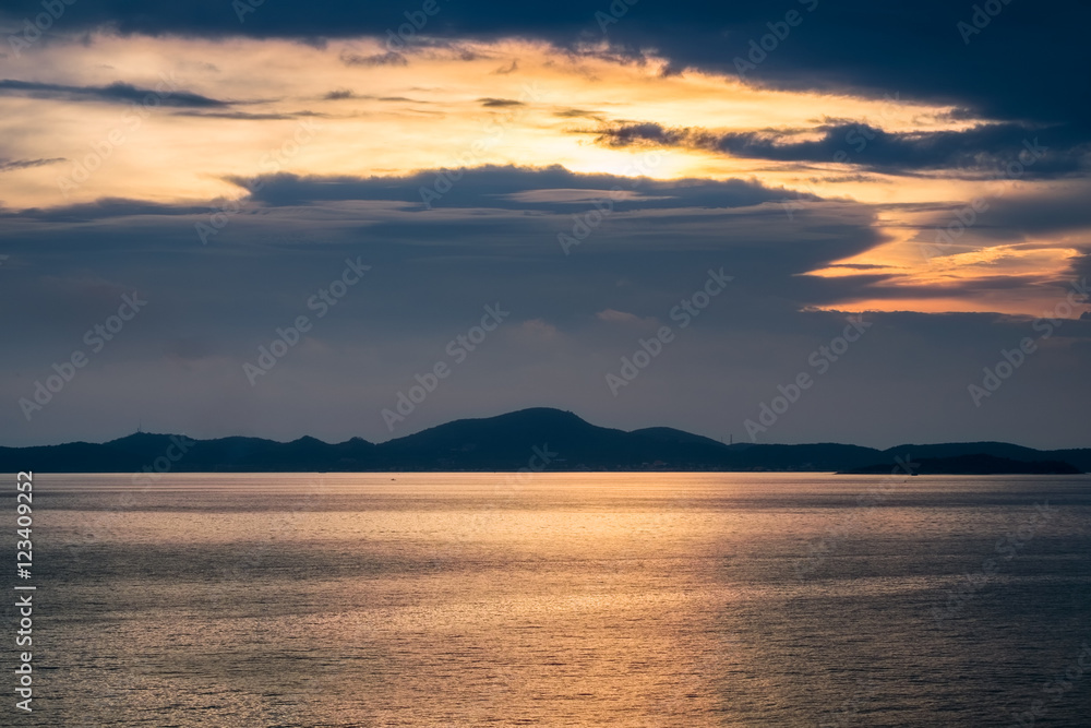 Golden sea with island at sunset