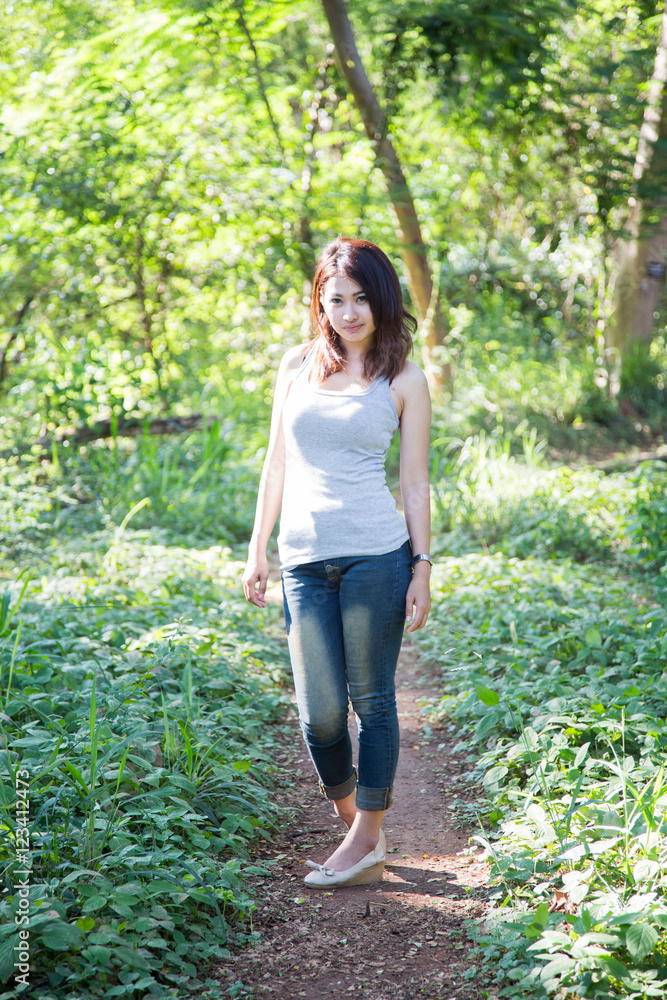 Beautiful young woman is in the green forest Beautiful young woman is in the green forest
