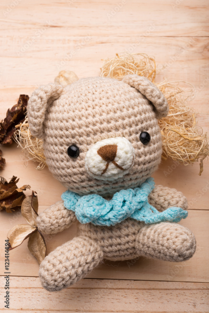 Knitted teddy bear on wood background