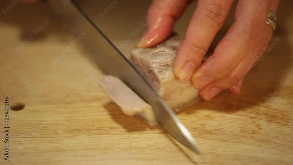 Asian cook cutting boiled pork into slices to prepare traditional soup Asian cook cutting boiled pork into slices to prepare traditional soup
