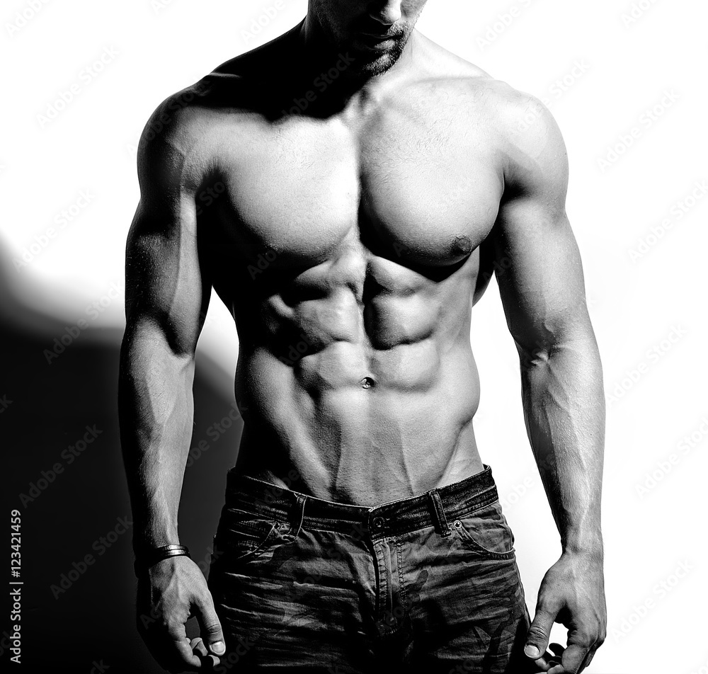 Portrait of strong healthy handsome Athletic Man Fitness Model posing near white wall Portrait of strong healthy handsome Athletic Man Fitness Model posing near white wall