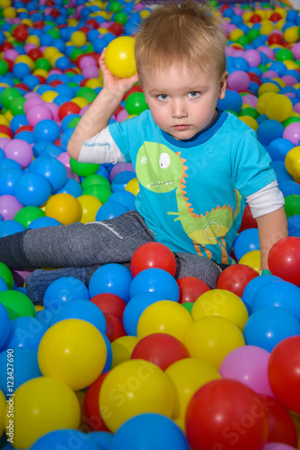 kid playing in pool of balls