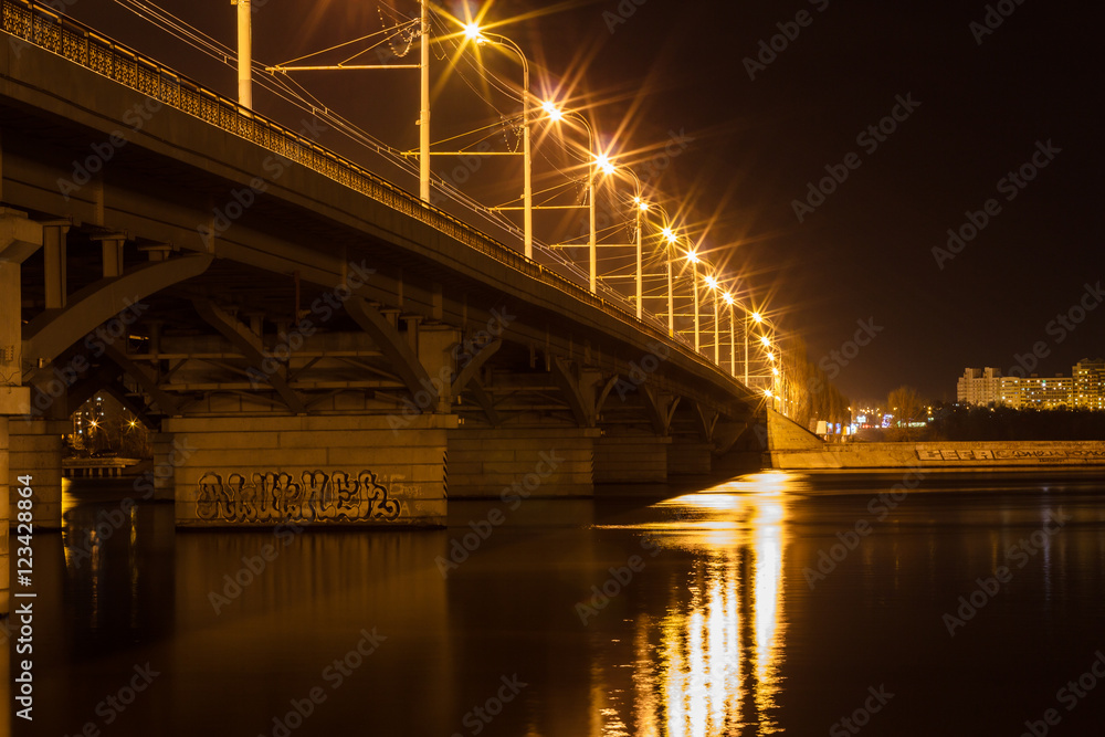 Obraz premium Bridge, city lights reflected in the water. Long exposure