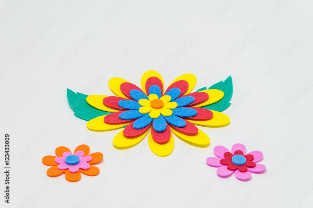 Colorful foam craft flower with green leaf on white background and selective focus Colorful foam craft flower with green leaf on white background and selective focus