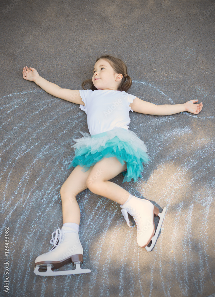 Little girl figure skating at imaginary skating rink arena laying