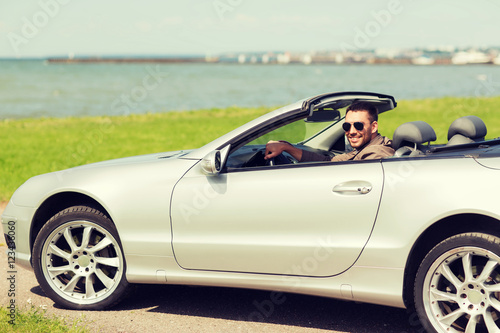 happy man driving cabriolet car outdoors