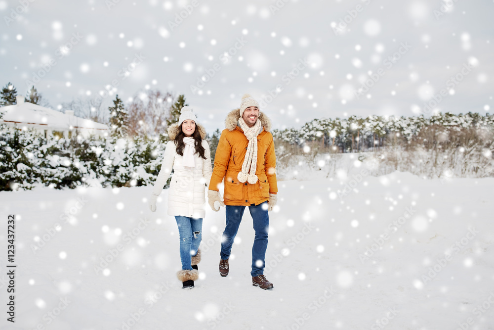 happy couple walking along snowy winter field happy couple walking along snowy winter field