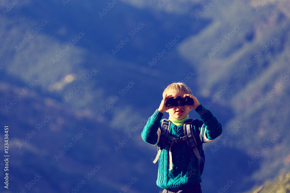 Fototapeta premium little boy with binoculars hiking in mountains