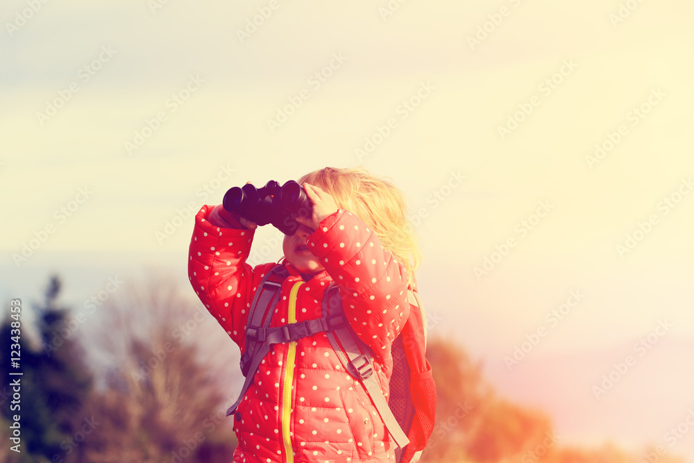 family travel- little girl with binoculars exploring nature