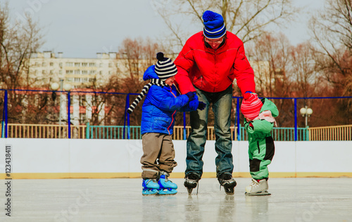 father with two kids skating, family winter sport