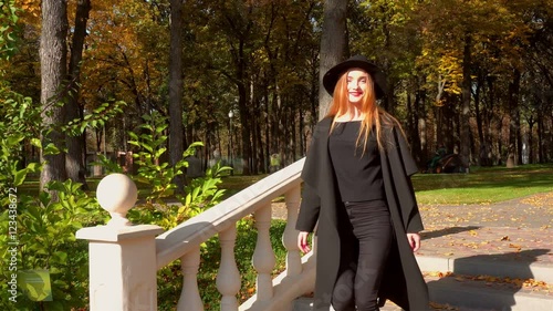 Charming young stylish woman walks down the stairs at warm autumn dya photo