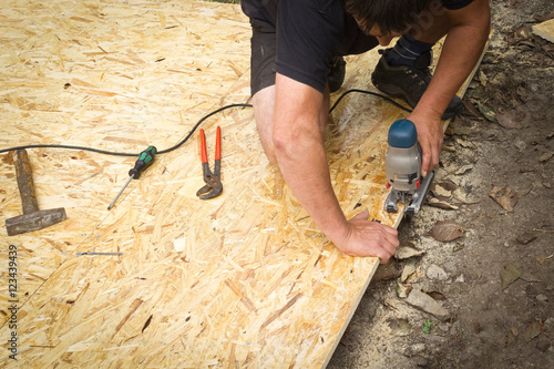 Handwerker mit Säge, Arbeitsunfall, Verletzung, Heimwerker