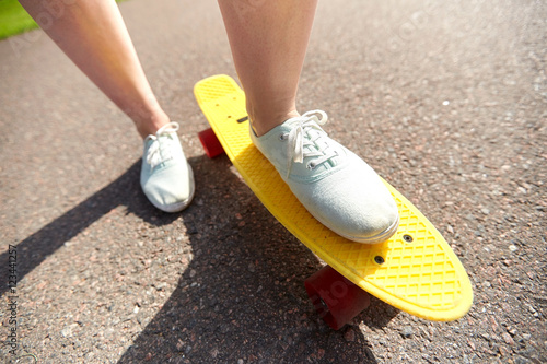 close up of female feet riding short skateboard