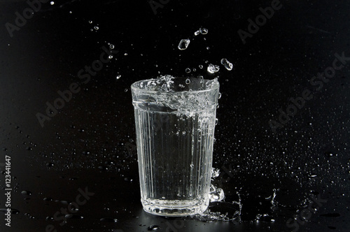Water is poured into a beaker on a dark background