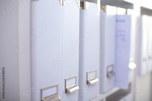 File folders, standing on shelves in the background