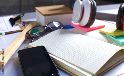 Desk of an artist with lots  stationery objects. Studio shot on wooden background