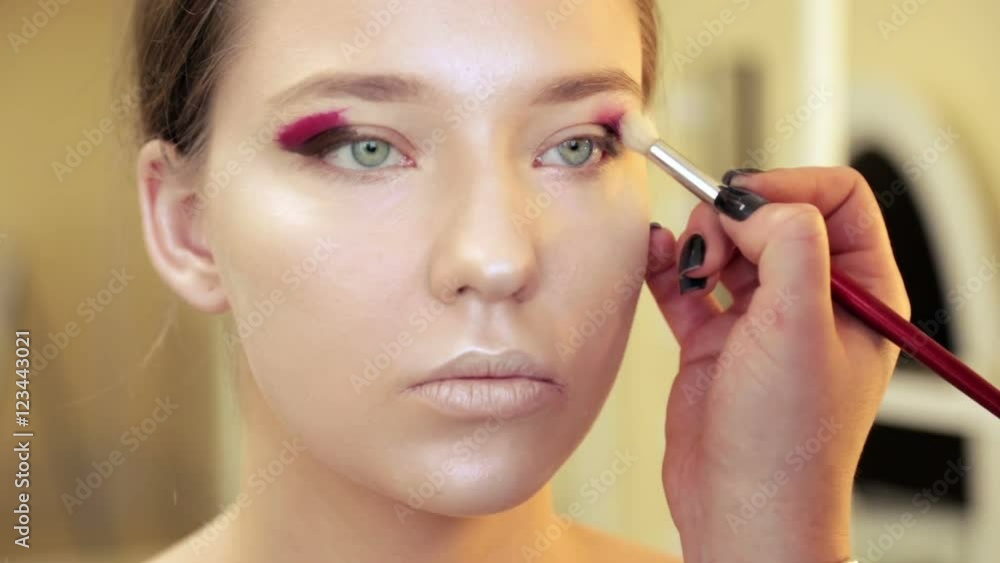 Makeup artist paints her eyes. Makeup artist paints her eyes.
