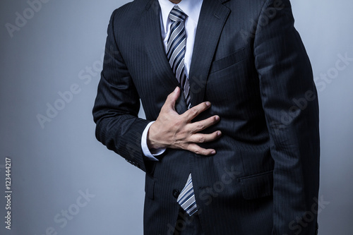 スーツを着ているビジネスマン、胃痛、ストレス photo
