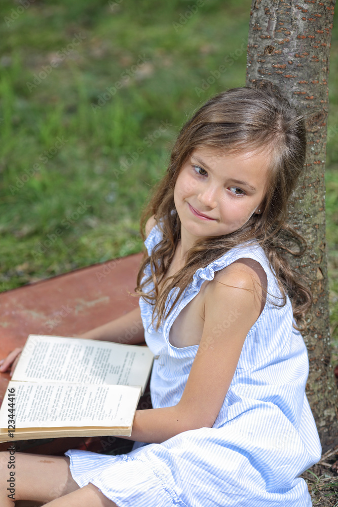 Young girl reading a book outside Young girl reading a book outside