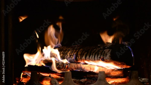 Closeup of burning flames or fire in fireplace on dark black background.