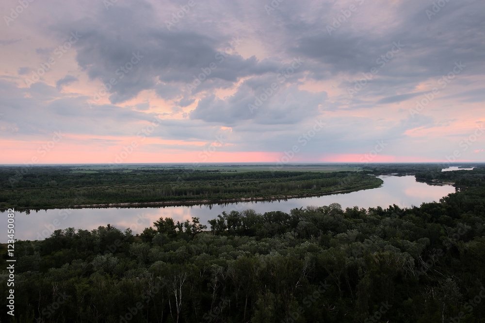 Cold dawn at the river. Summer landscape. Beautiful clouds and hills.