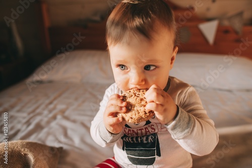 little boy eating cookies in bed
