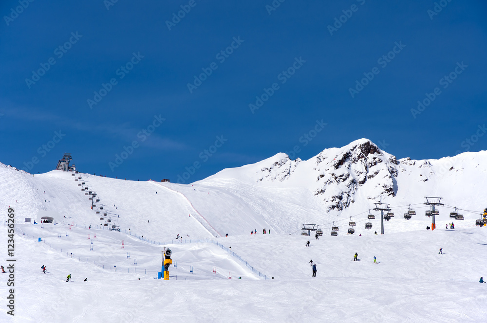 Skiers, chairlift and easy giant slalom course in Alpine ski resort in Solden in Otztal Alps, Tirol, Austria Skiers, chairlift and easy giant slalom course in Alpine ski resort in Solden in Otztal Alps, Tirol, Austria