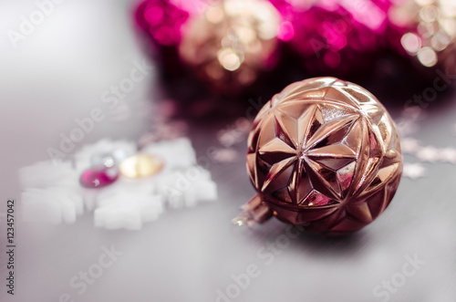 Gold christmas ball on bokeh background of xmas ornaments.