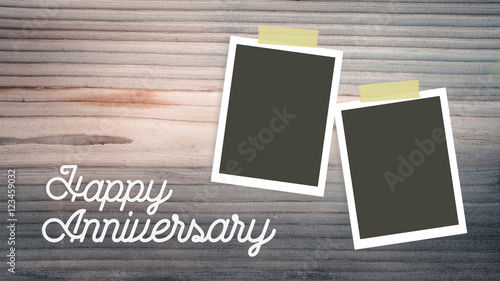 happy anniversary. empty instant photo frames lying on pine wood