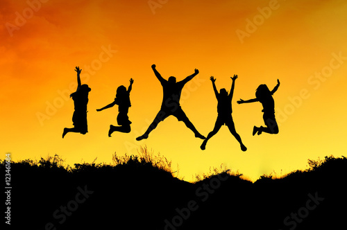 Group of friends jump on the top of mountain and getting fun on mountains backdrop photo
