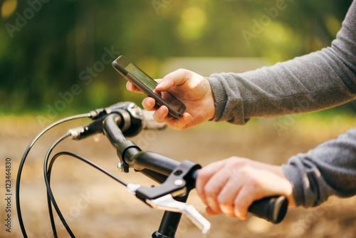 Woman typing text message during bicycle ride