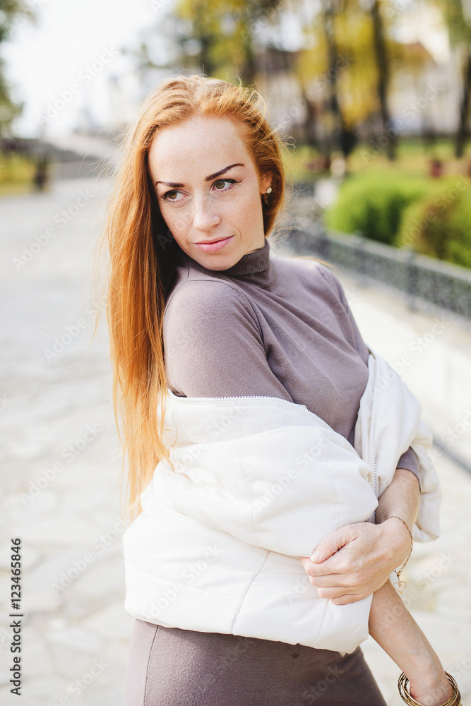 Redhead young woman walking in autumn park Redhead young woman walking in autumn park