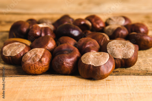 autumn brown chestnuts on an old wooden table