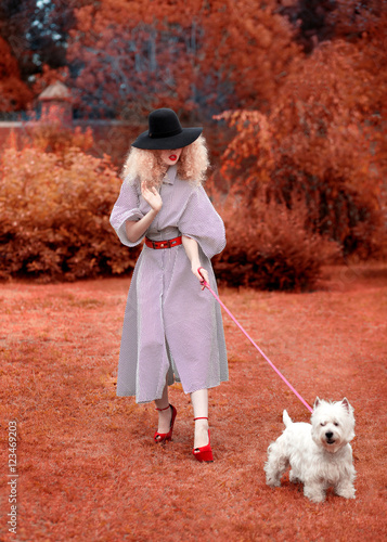 Woman wearing outerwear with dog in autumn countryside 