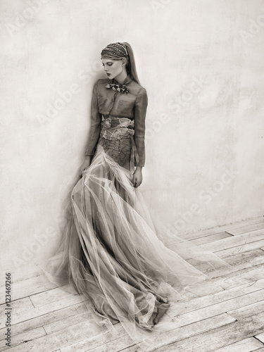 Woman wearing long tulle skirt, leaning against wall (ID: 123469266)