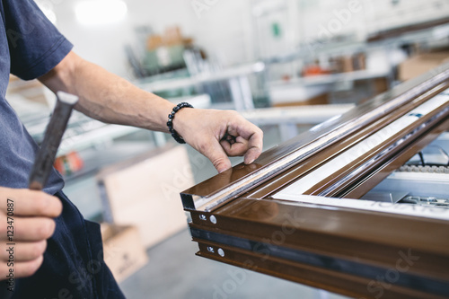 Manual worker assembling PVC doors and windows. Manufacturing jobs. Selective focus. Factory for aluminum and PVC windows and doors production.