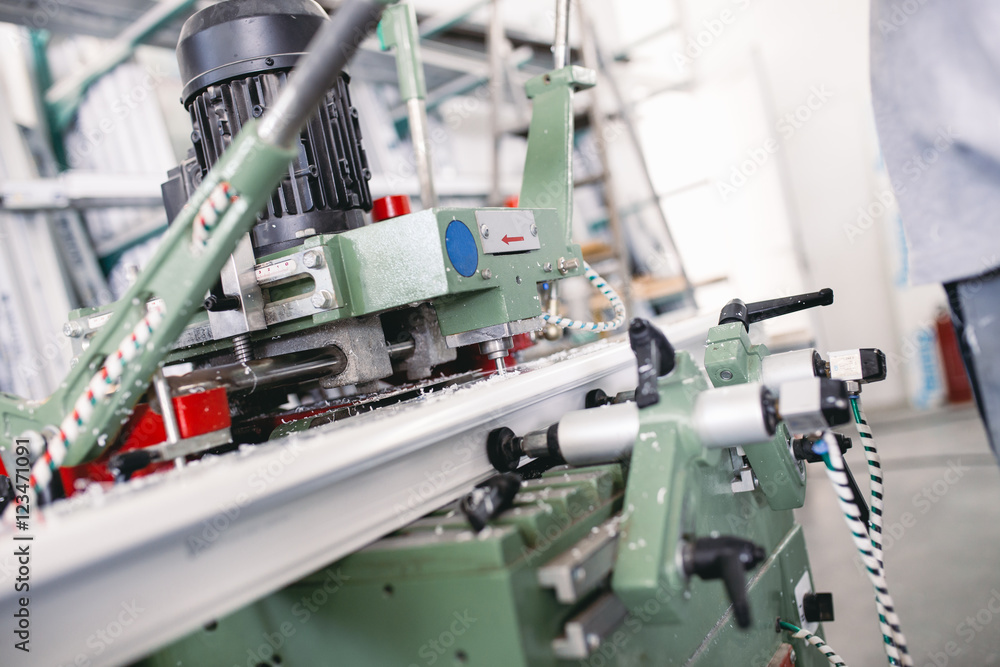 Manual worker cutting aluminum and PVC profiles. Manufacturing jobs. Selective focus. Factory for aluminum and PVC windows and doors production. Manual worker cutting aluminum and PVC profiles. Manufacturing jobs. Selective focus. Factory for aluminum and PVC windows and doors production.