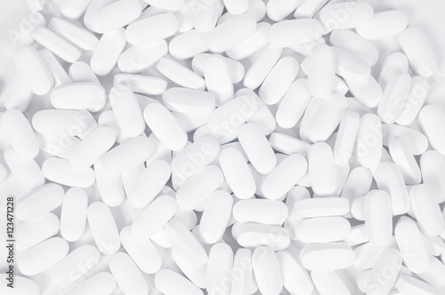 White pills on the white background.