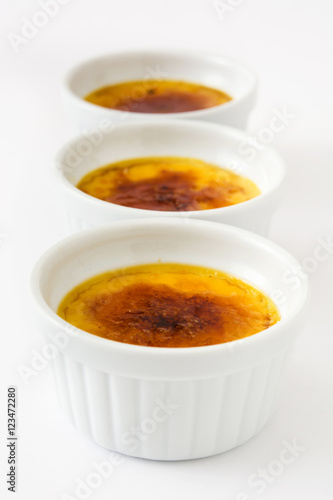 Traditional French creme brulee dessert with caramelized sugar on top, isolated on white background.     © chandlervid85