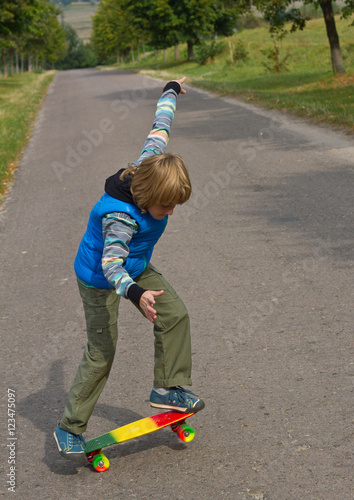 little boy having fun with skateboard outdoors.