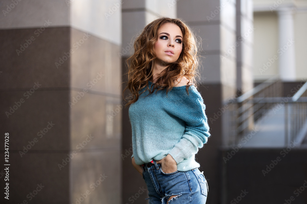 Happy young fashion woman with long curly hairs on city street Happy young fashion woman with long curly hairs on city street