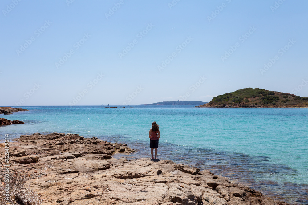 Jeune femme seule devant la mer turquoise - Corse France