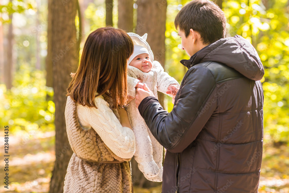 young family with their newborn baby spending time outdoor in the autumn park. young family with their newborn baby spending time outdoor in the autumn park.