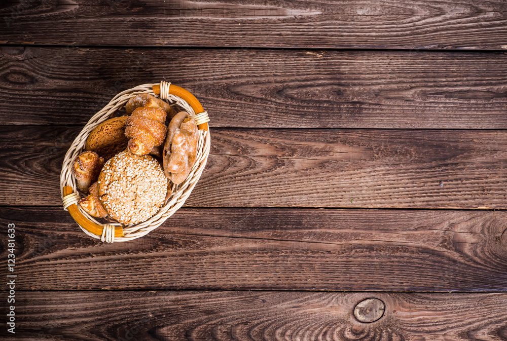 Assortment of baked bread on wooden table background