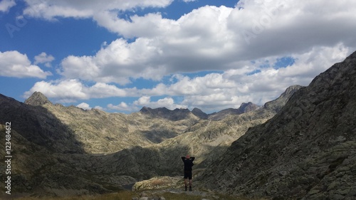 Man looking absorbed an awesome panorama of clouds and mountains