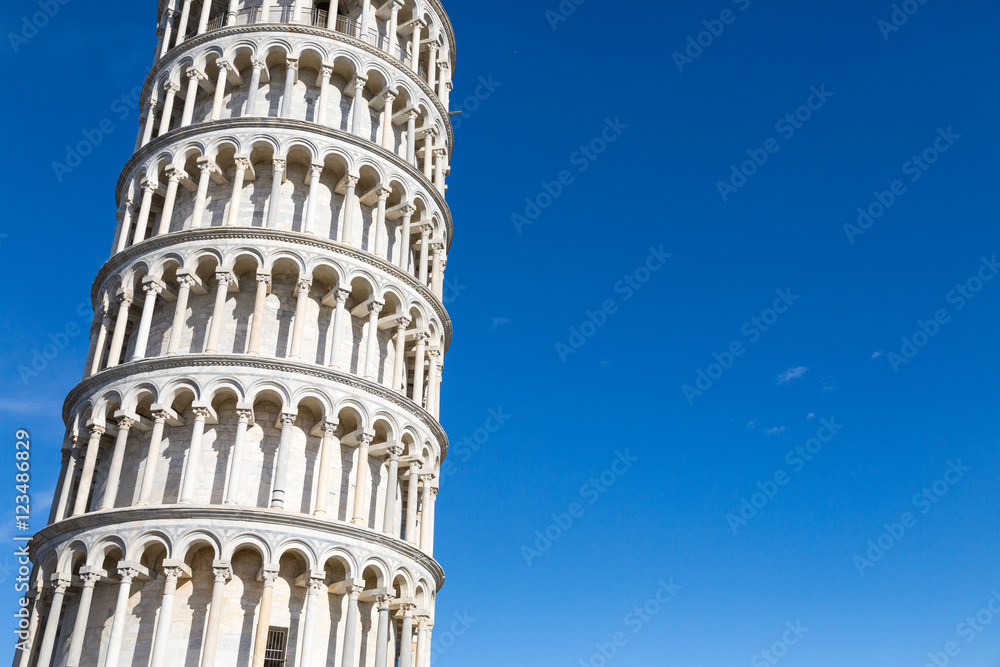 Fragment of the Tower of Pisa against the background of the blue sky